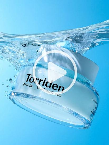 Woman showing jar of Torriden Dive In Soothing Cream against a blue background
