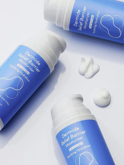 Three bottles of Purito Dermide Relief Barrier Moisturizer lying on their sides with two swatches of white cream, on a white surface