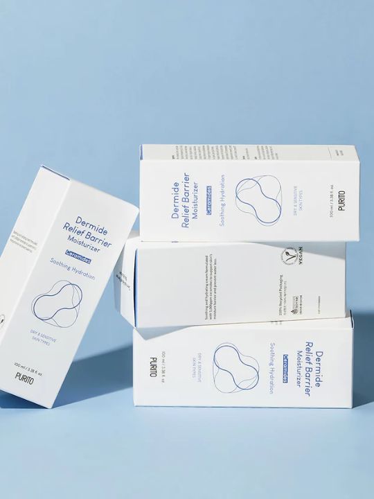 Four retail boxes of Purito Dermide Relief Barrier Moisturizer on a light blue background