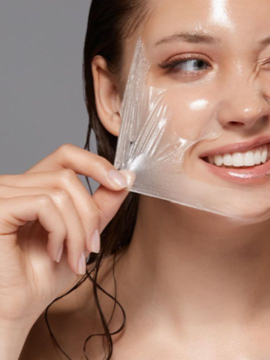 Woman peeling Purito Multi PDRN Collagen Real Glow Mask from her face against a grey background