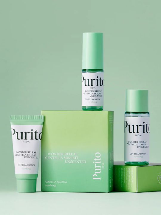 Three mini bottles from Purito Wonder Releaf Centella Unscented kit with their retail box on a green background