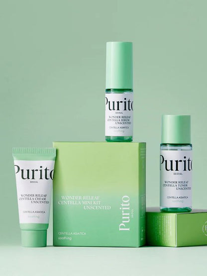 Three mini bottles from Purito Wonder Releaf Centella Unscented kit with their retail box on a green background