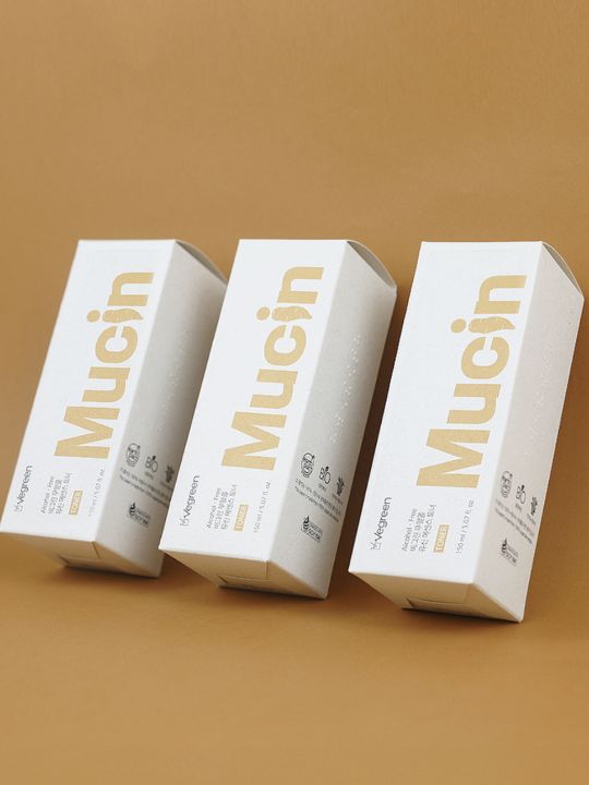 Three retail boxes of Vegreen Alcohol-Free Mucin Toner on a light brown background