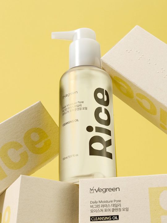 Pump bottle of Vegreen Rice Daily Moisture Pore Cleansing Oil standing on its retail boxes against a yellow background