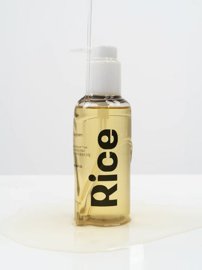 Pump bottle of Vegreen Rice Daily Moisture Pore Cleansing Oil with liquid running down it on a neutral background